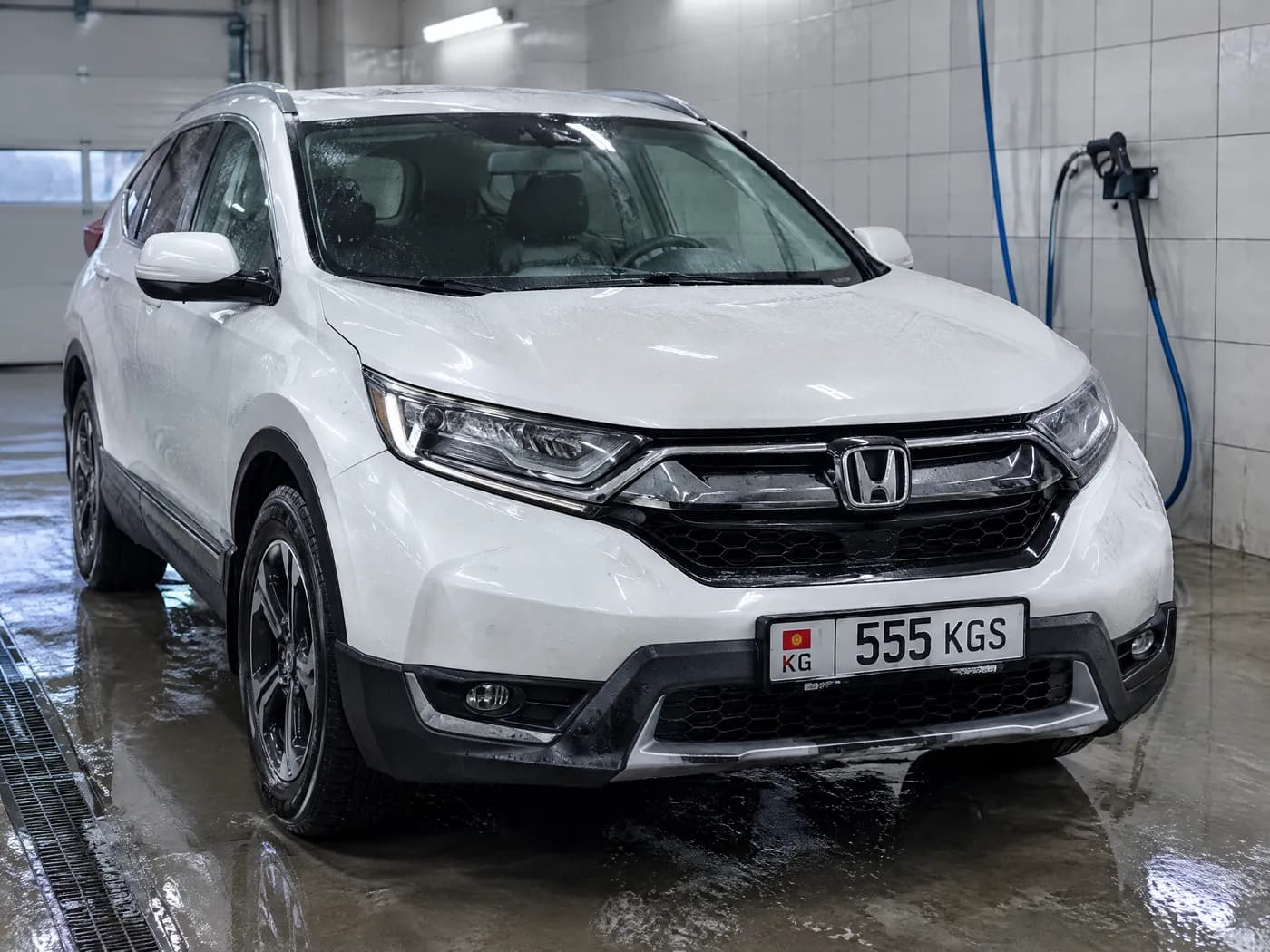 Белая Honda CR-V в боксе мойки